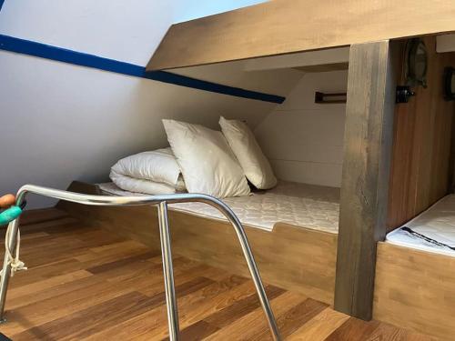 Cette chambre comprend un lit superposé avec des oreillers blancs. dans l'établissement Petite maison de pêcheur, à l'Île-aux-Moines