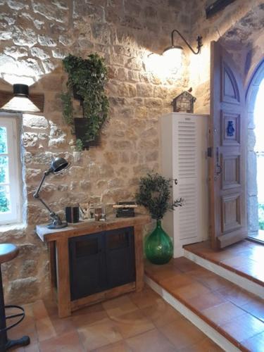 une cuisine avec un mur en pierre avec un vase sur un comptoir dans l'établissement L Estello, Village house in Provence, à Seillans