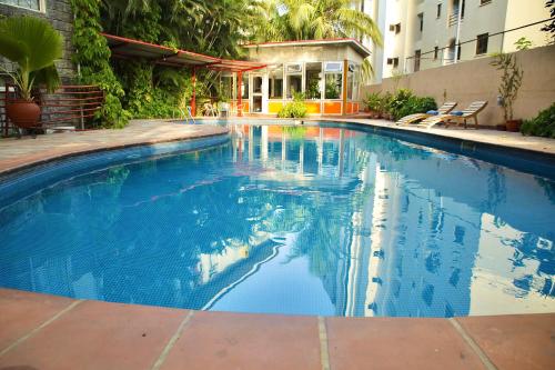 a swimming pool with blue water in a building at La Cour Hotels and Apartments Cooper in Lagos