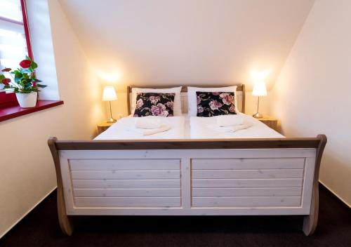 a bedroom with a white bed with two lamps at Ateliér 673 in Dolní Bečva