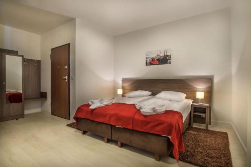 a bedroom with a large bed with a red blanket at MariSol in Świnoujście