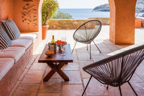 une terrasse avec un canapé, deux chaises et une table dans l'établissement Exquisite beachfront mansion, à Ermoúpoli