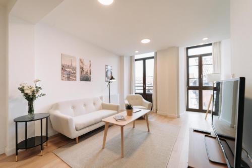 a living room with a couch and a tv at San Bernardo, 19 in Avilés