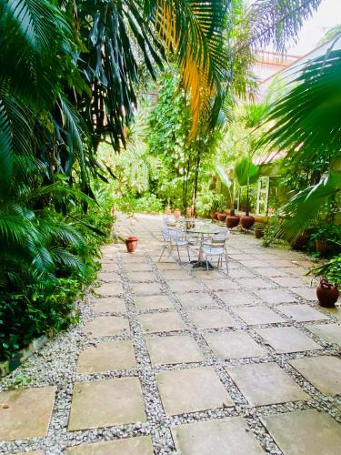 a patio with a table and chairs in a garden at La Cour Hotels and Apartments Cooper in Lagos