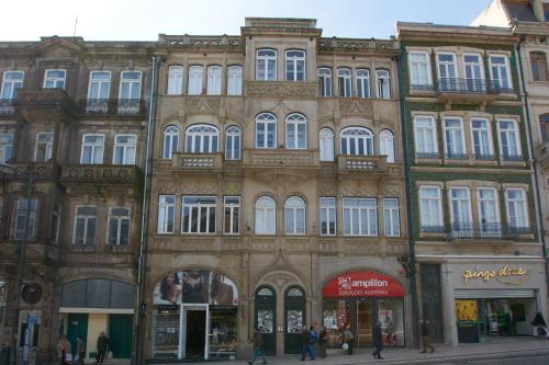 a large building with a clock on the side of it at Bolhão Nobre Apartments in Porto