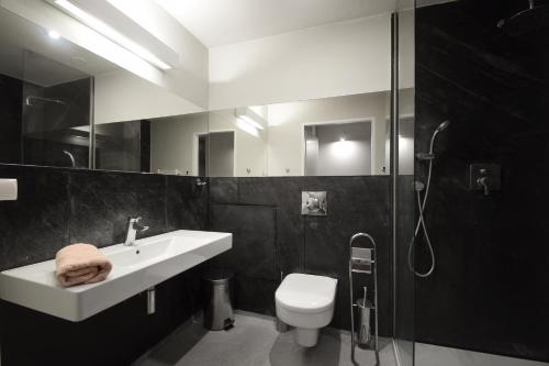 een badkamer met een wastafel, een toilet en een douche bij Apartament Mare Baltico in Pogorzelica