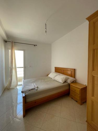 a bedroom with a bed and a dresser and a window at Economic Apartment Alhoceima WIFI in Al Hoceïma