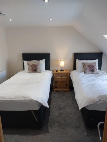 duas camas sentadas uma ao lado da outra num quarto em Hebridean Stay em Creagorry