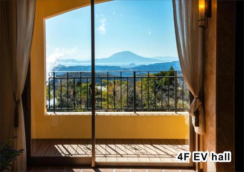 a room with a window with a view of the mountains at La Vista Kirishima Hills in Kirishima