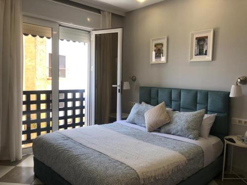 casa bahia في أصيلة: غرفة نوم مع سرير كبير مع اللوح الأمامي الأزرق