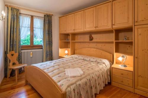 una camera da letto con un letto grande con armadi in legno di Cozy apartment near Cortina a San Vito di Cadore