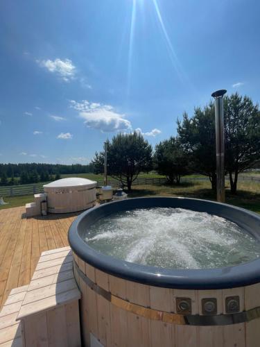 a hot tub with water in it on a patio at Giżycko-Przerwanki Domki Widok na Mazury in Giżycko