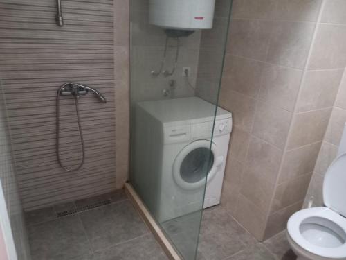 a bathroom with a shower and a washing machine at Luxury Apartment in Ulcinj