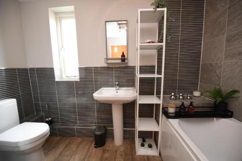 uma casa de banho com um lavatório, um WC e uma banheira em Harrogate Self Catering - Regent's Court Cherry Suite em Harrogate