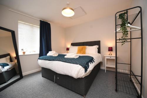um quarto com uma cama grande e um espelho em Harrogate Self Catering - Regent's Court Cherry Suite em Harrogate