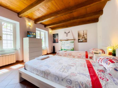 a bedroom with two beds and a wooden ceiling at Casetta del Borgo in Pietrasanta