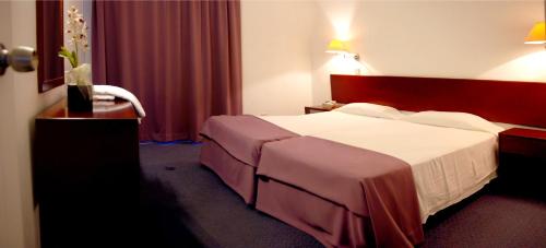 a hotel room with a large bed with white sheets at Blue Crane Hotel Apts in Limassol