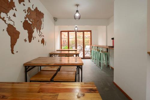 a room with two tables and a world map on the wall at Verde Madera Hostel B&B in Santiago