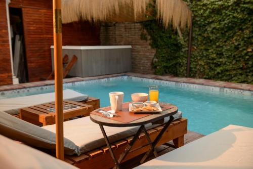 a table with a tray of food next to a swimming pool at Verde Madera Hostel B&B in Santiago