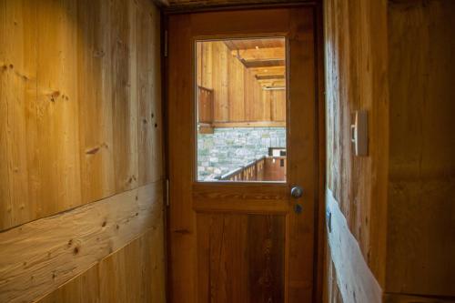 eine Holztür in einem Zimmer mit Fenster in der Unterkunft Maison Carrel Elegant 12 in Breuil-Cervinia