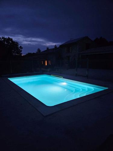 une piscine éclairée la nuit dans l'établissement Le Mas de Lou Papé, à Carsan