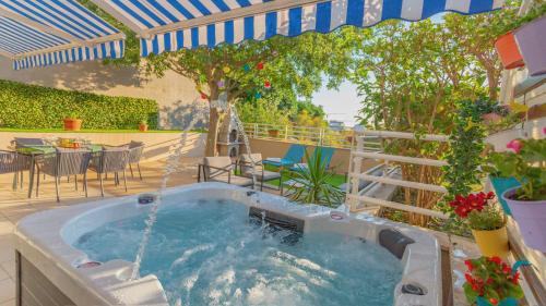 bañera de hidromasaje en un patio con sombrilla en New delux green garden apartment with hotube ****, en Split
