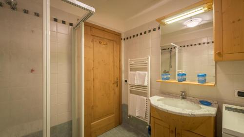La salle de bains est pourvue d'un lavabo et d'un miroir. dans l'établissement Cozy apartment near Cortina, à San Vito di Cadore