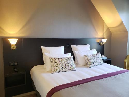 a bedroom with a bed with white sheets and pillows at Brame de Sologne in Muides-sur-Loire