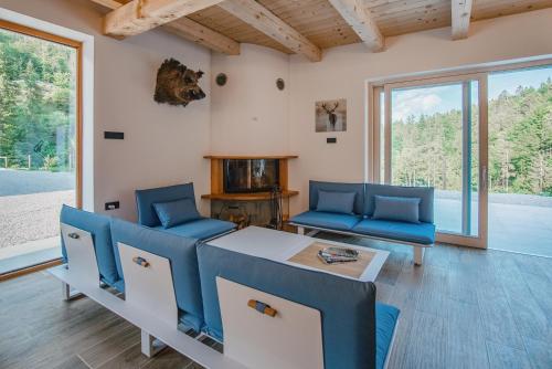 a living room with blue chairs and a table at Chalet HerMes arT in Idrija