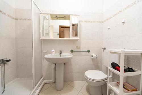 uma casa de banho com um lavatório, um WC e um espelho. em La casa di Tina a 20 metri dal mare em Santo Stefano al Mare