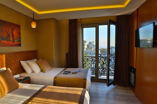 a hotel room with two beds and a balcony at Corner Hotel Laleli in Istanbul
