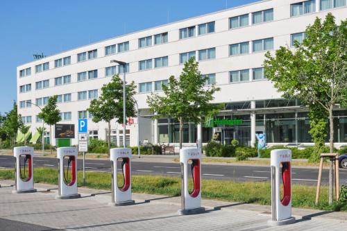 a row of parking meters in front of a building at Holiday Inn Berlin Airport - Conference Centre by IHG in Schönefeld