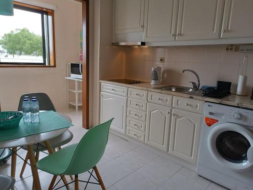 - une cuisine avec une table et un lave-linge dans l'établissement Apartamento Solzende, à Esposende