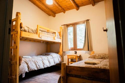 a bedroom with two bunk beds and a window at Sueño de Pehuenia in Villa Pehuenia
