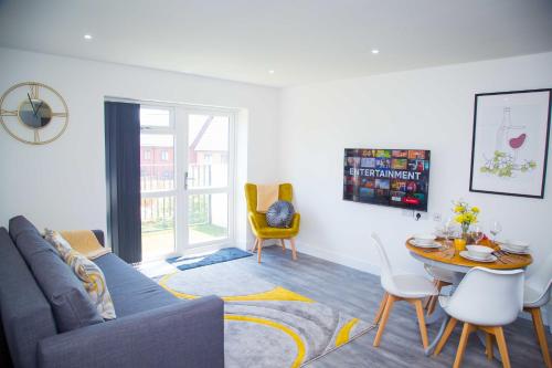 a living room with a couch and a table and chairs at Bridge Court by Sterling Edge Apartments - Luxury Aparthotel - Stylish 1-bed Apartments - Balcony with Canal View or Private Garden - Free Parking in Birmingham