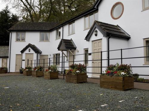 Uma casa branca com vasos de flores à frente. em Burlton Inn em Burlton