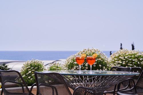two wine glasses sitting on a table on a patio at Atlantica Bay - Adults Only in Limassol