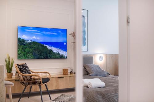 a bedroom with a bed and a tv on a wall at Apartament Premium PINEA 205 in Pobierowo