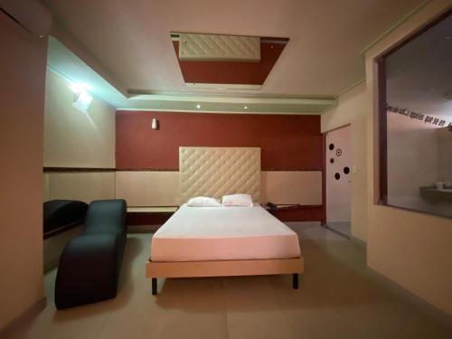 a bedroom with a bed and a chair in it at Drops Palhoça Motel in Palhoça