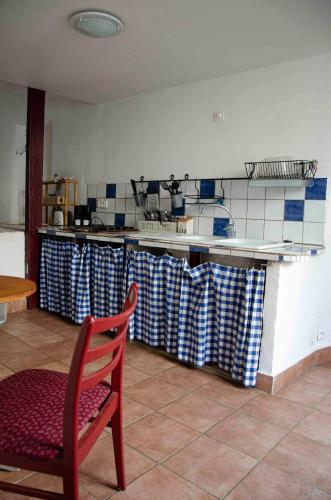 une cuisine avec un comptoir, une table et une chaise dans l'établissement Gîte de charme cévenol, à Cros