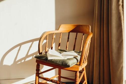 a wooden rocking chair with an open book on it at L’atelier central - Polleur - Duplex Terrasse 8 p in Theux