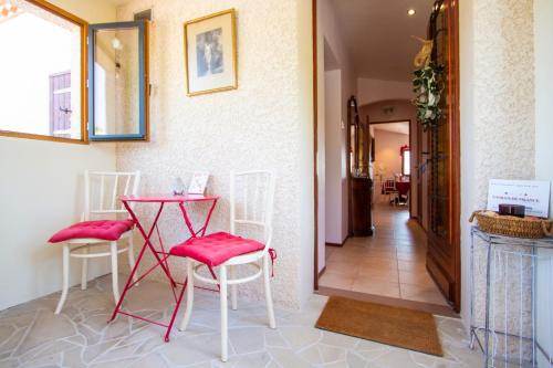a room with a red table and chairs and a hallway at Mas a 4 Mains in Cesseras
