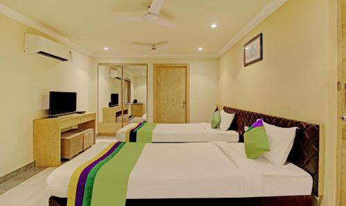a hotel room with two beds and a television at Treebo Trend ASL Prime in Kolkata