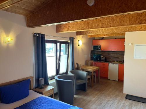 ein Schlafzimmer mit einem Bett und eine Küche mit einem Tisch in der Unterkunft Ferienanlage Bullerbü in Lohme