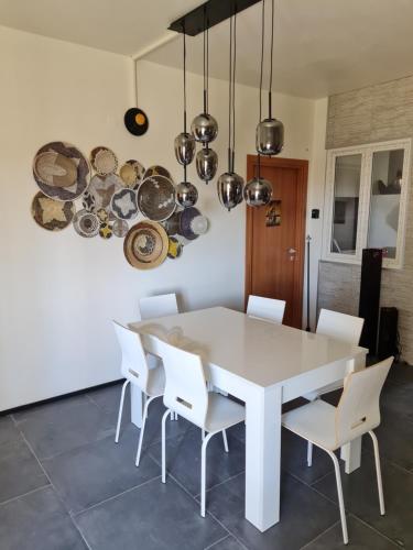 comedor con mesa blanca y sillas blancas en Appartamento del Li-Lioni di Teranga, en Platamona