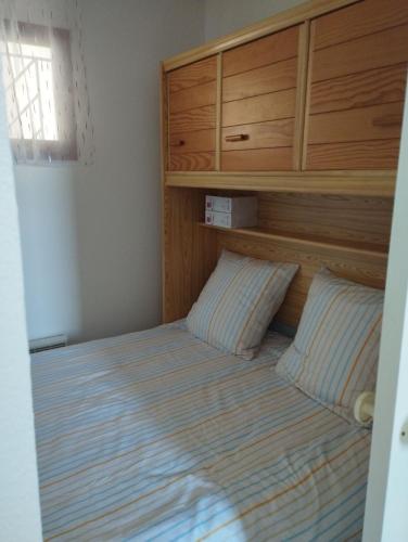 une chambre avec un lit avec une tête de lit en bois dans l'établissement Appartement Vue mer Le Sunset, au Cap d'Agde