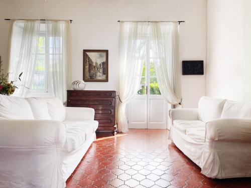Lucio Fontana's experience في Comabbio: غرفة معيشة بها كنبتين بيضاء ونوافذ