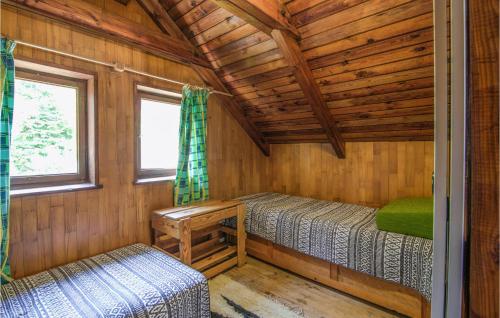 a log cabin with two beds and a window at Nice Home In Wilimy With Kitchen in Wilimy