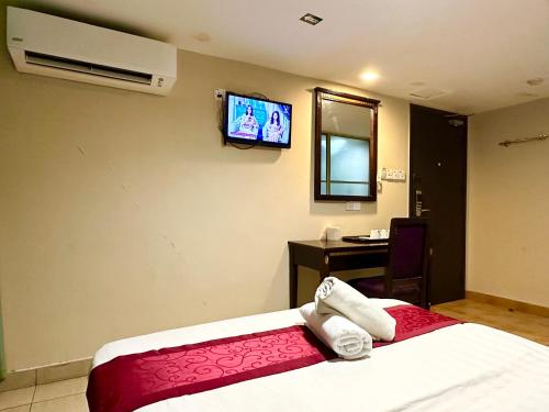 a hotel room with a bed and a tv on the wall at VALLEY HOTEL in Kota Kinabalu