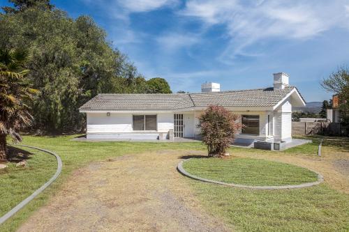 uma pequena casa branca com um quintal em Paz y Confort em La Falda